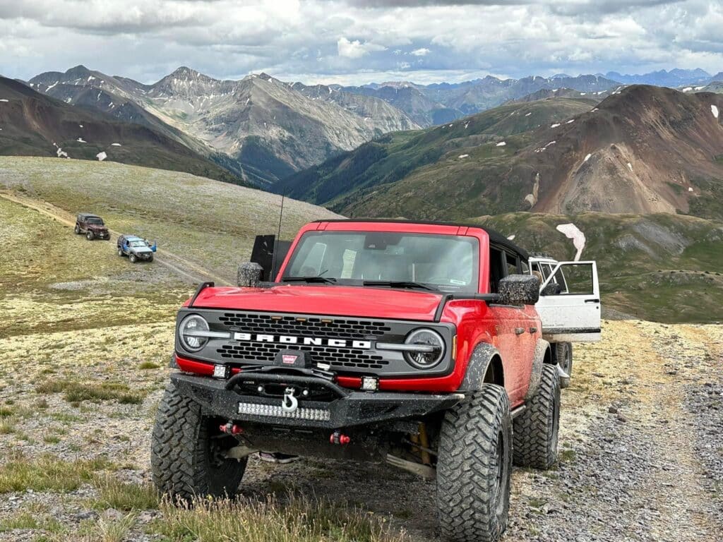 Best off-road tires for grand junction terrain at Barney Brothers. Image of newer red Ford Bronco with all-terrain tires on trail.